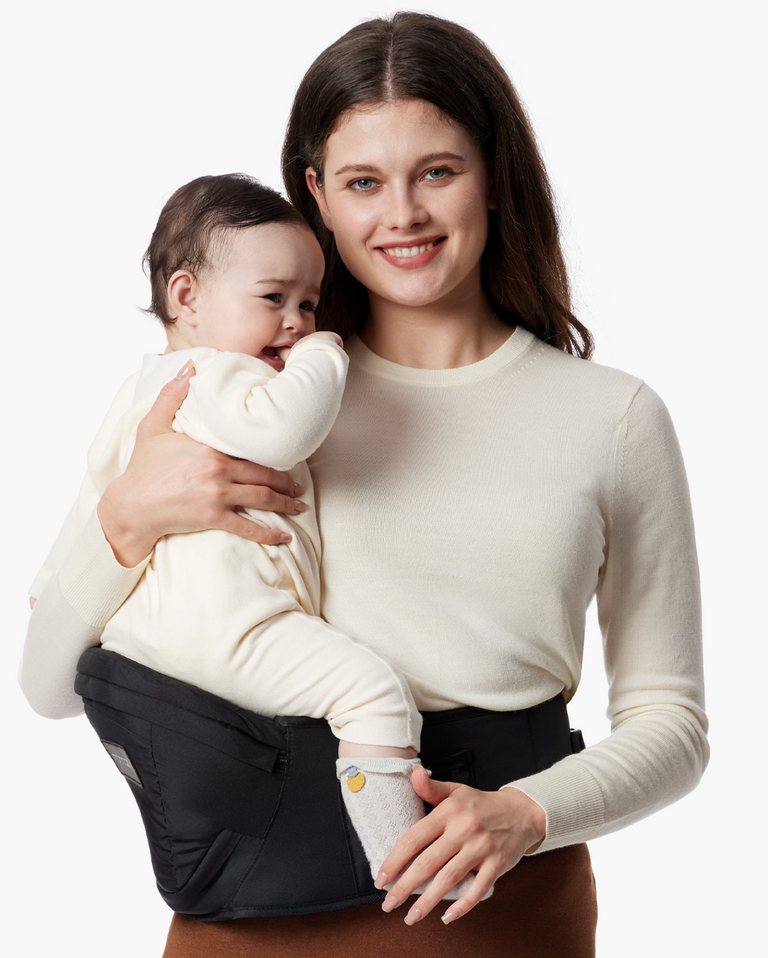 Translation missing: fr.Momcozy Wander360 Hip Seat Carrier: Woman holding baby in a black carrier, babywearing solution for comfort and convenience