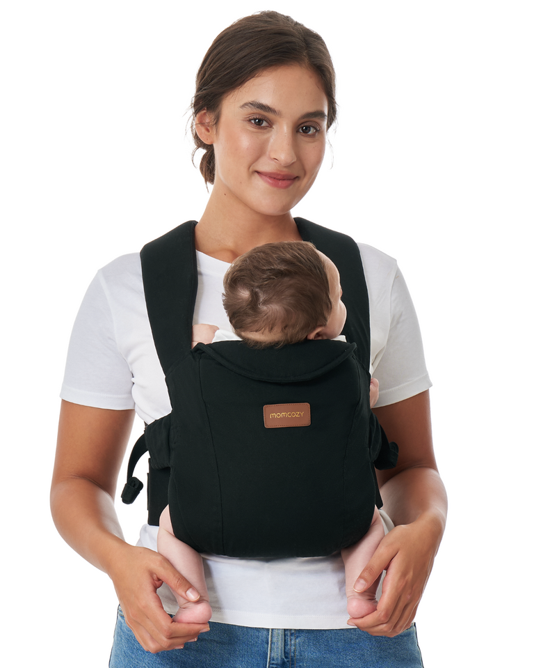 Translation missing: pl.Momcozy WeeSnug Newborn Carrier (0–3M) in black, worn by a smiling mother with her baby, showcasing comfort and design